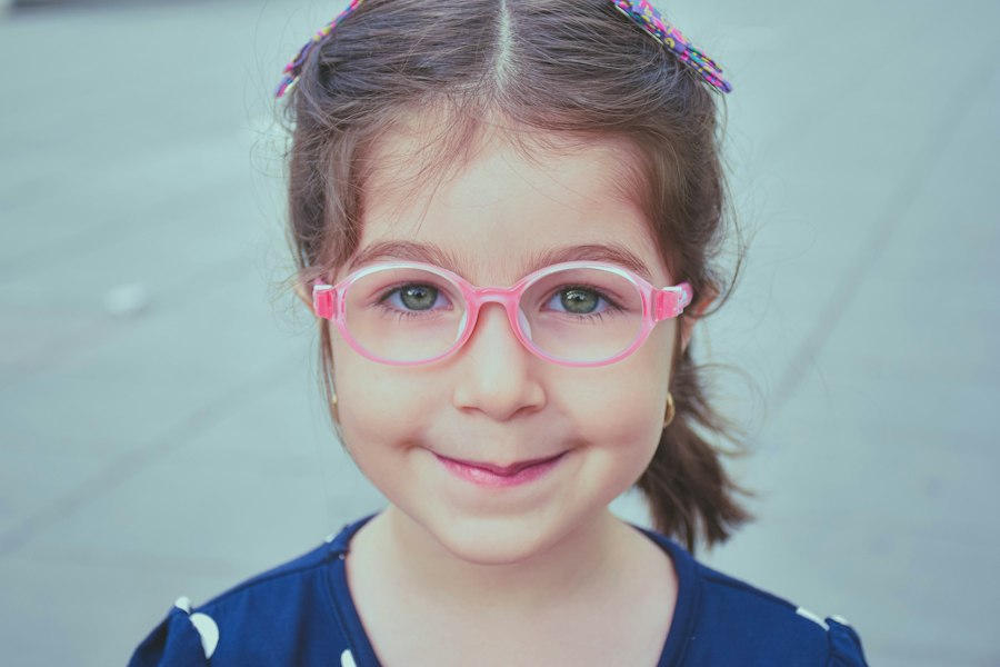 Niña sonriendo con anteojos rosados